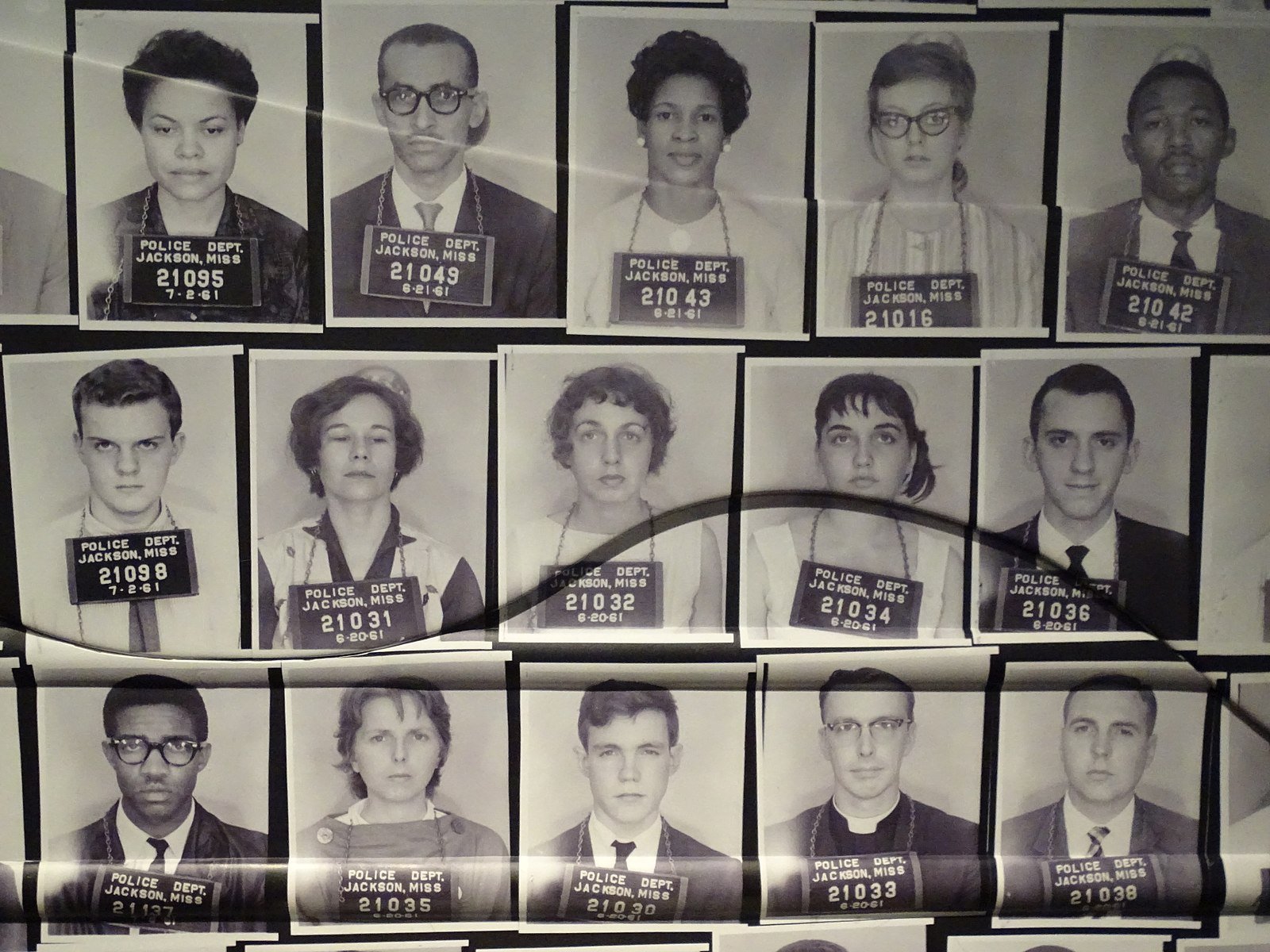 Grid of vintage police mugshots of diverse individuals from Jackson, Mississippi, dated 1961. Each photo features a person with a visible arrest number.