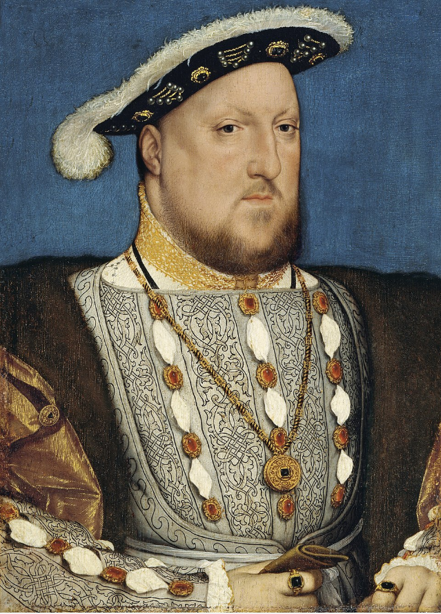 A painted portrait of a man wearing rich Tudor-era clothing, including an ornate, patterned doublet with gold embroidery and red jewels. He has a broad, square face with a short reddish-brown beard and is wearing a black hat adorned with gold embroidery and a white feather. A gold chain hangs around his neck, and his expression is stern and regal. The background is a plain blue.