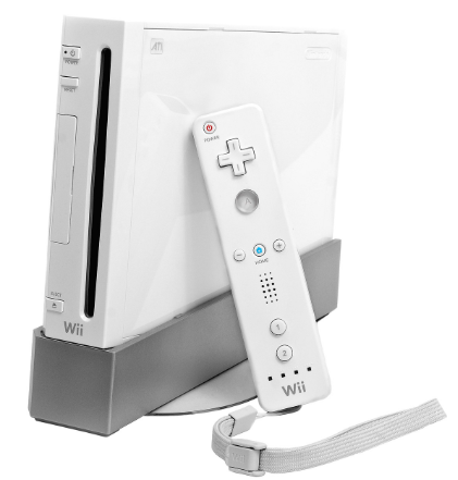 White Nintendo Wii console and remote control on a grey stand. The remote has a wrist strap and buttons for navigation and gameplay.