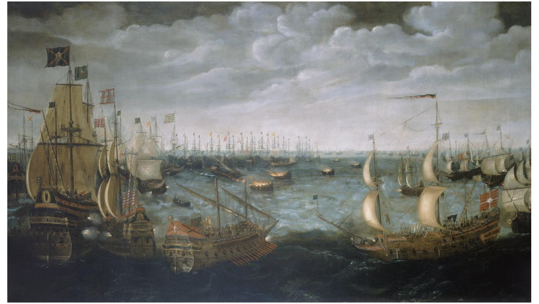 This historical painting depicts a dramatic naval engagement during the Spanish Armada campaign of 1588. The sea is crowded with large wooden sailing ships flying various flags, most likely English and Spanish. The atmosphere is intense, with dark clouds looming overhead and choppy waves on the water.
In the centre and mid-ground of the image, several ships appear to be engulfed in flames or emitting dark smoke. These are the fireships — vessels deliberately set ablaze and sent towards the anchored Spanish fleet by the English to cause panic and disarray. The fireships are smaller than the surrounding galleons and are marked by bright orange flames and dark, heavy smoke. Sailors can be seen abandoning nearby ships or reacting in alarm.