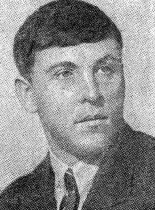 Vintage black and white portrait of a man in a suit and tie, with short dark hair and a serious expression, facing slightly to the left.
