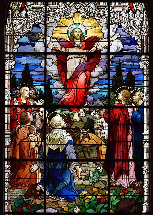 Stained glass window depicting a robed figure ascending into the sky surrounded by rays, with onlookers in colourful garments at the bottom.