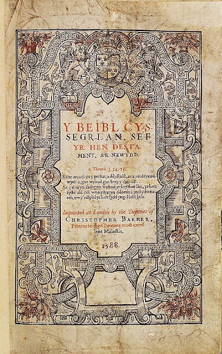 Ornate 1588 title page of a Welsh Bible, featuring intricate floral and scroll designs, with red and black text announcing the Old and New Testaments.