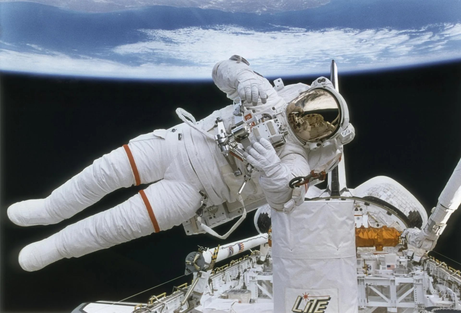 An astronaut floating in space while testing a propulsion jet pack system