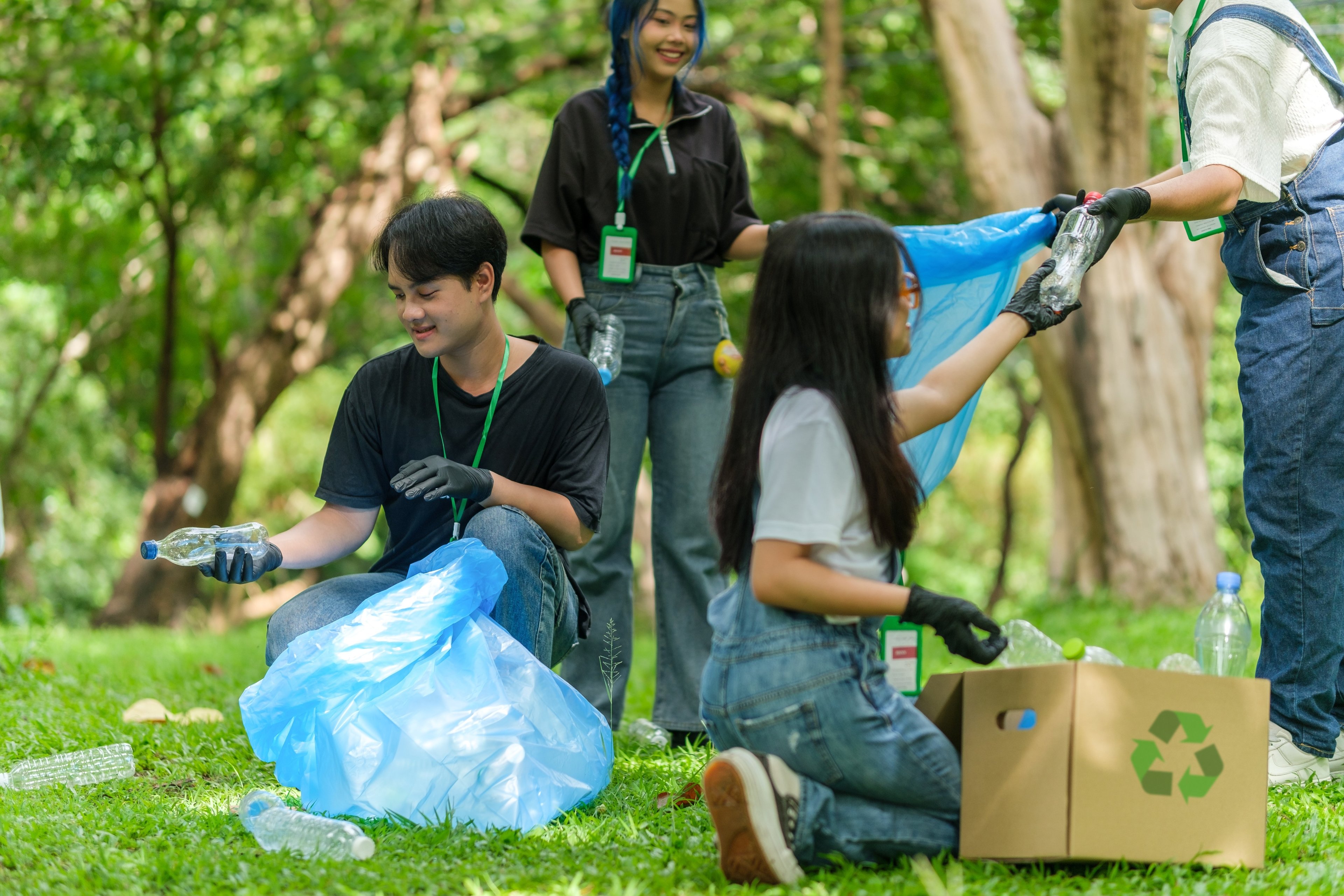 young people outside collecting rubbish which they will then recycle.
