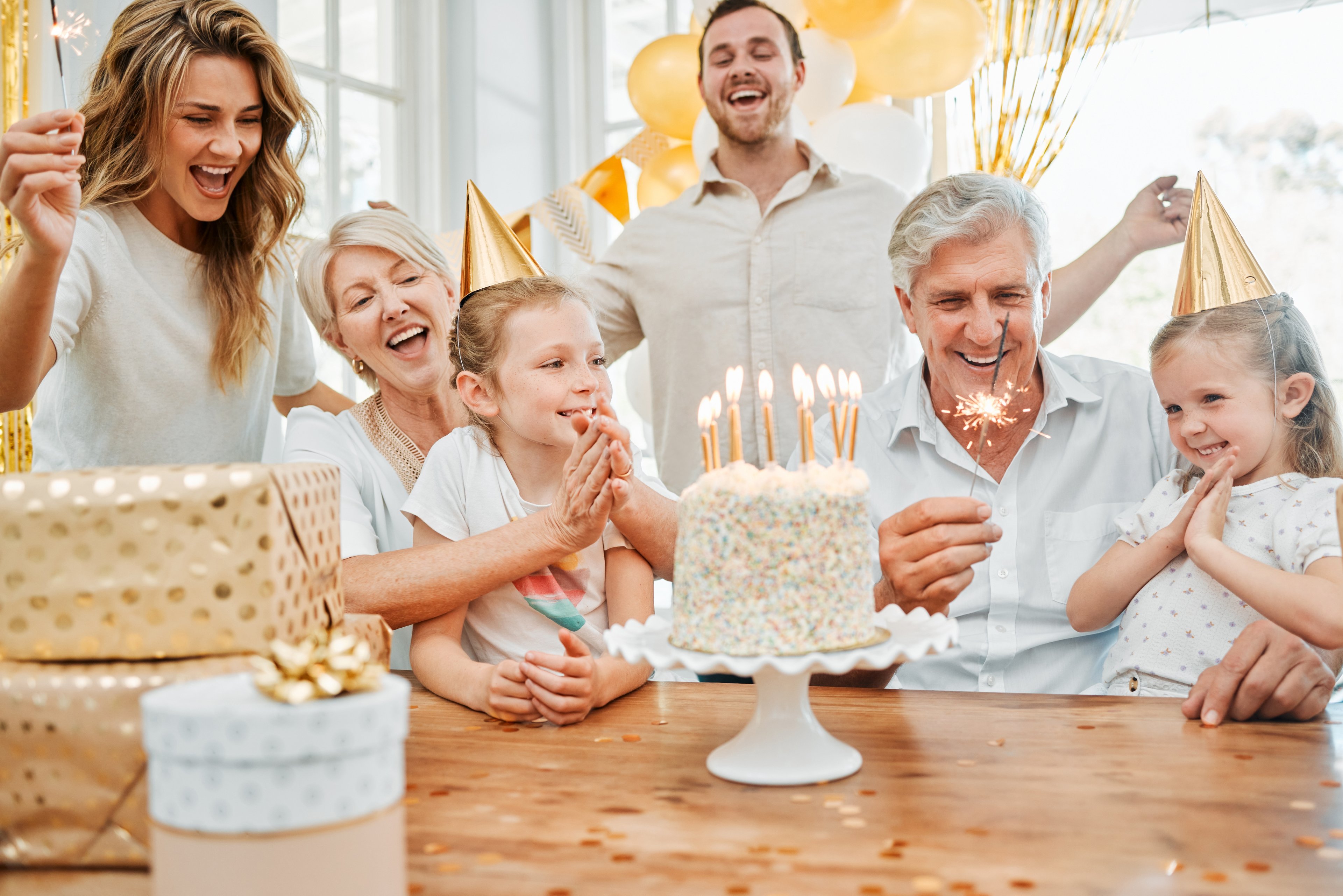 An image which shows a family celebrating a birthday/anniversary with a cake in the middle. This needs to be a photo rather than an illustration.
