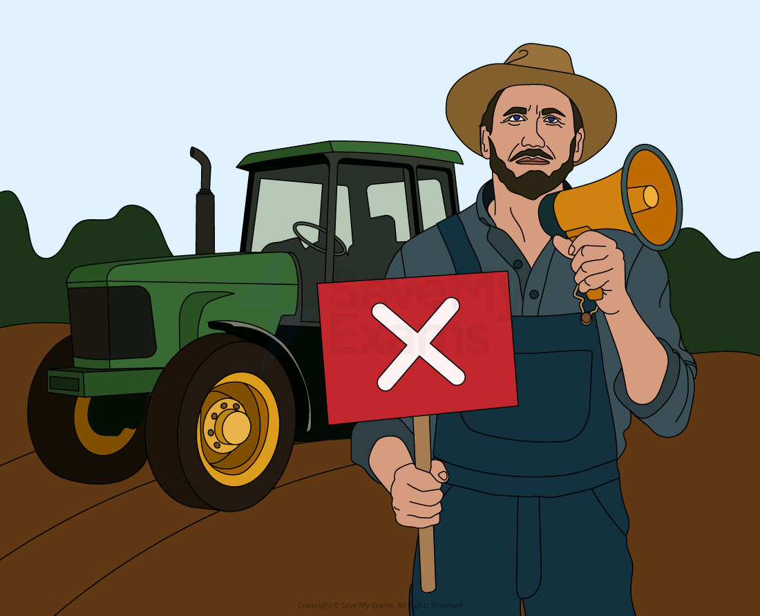 Farmer holding a megaphone and a protest sign with an 'X', standing in front of a green tractor on a field with trees in the background.