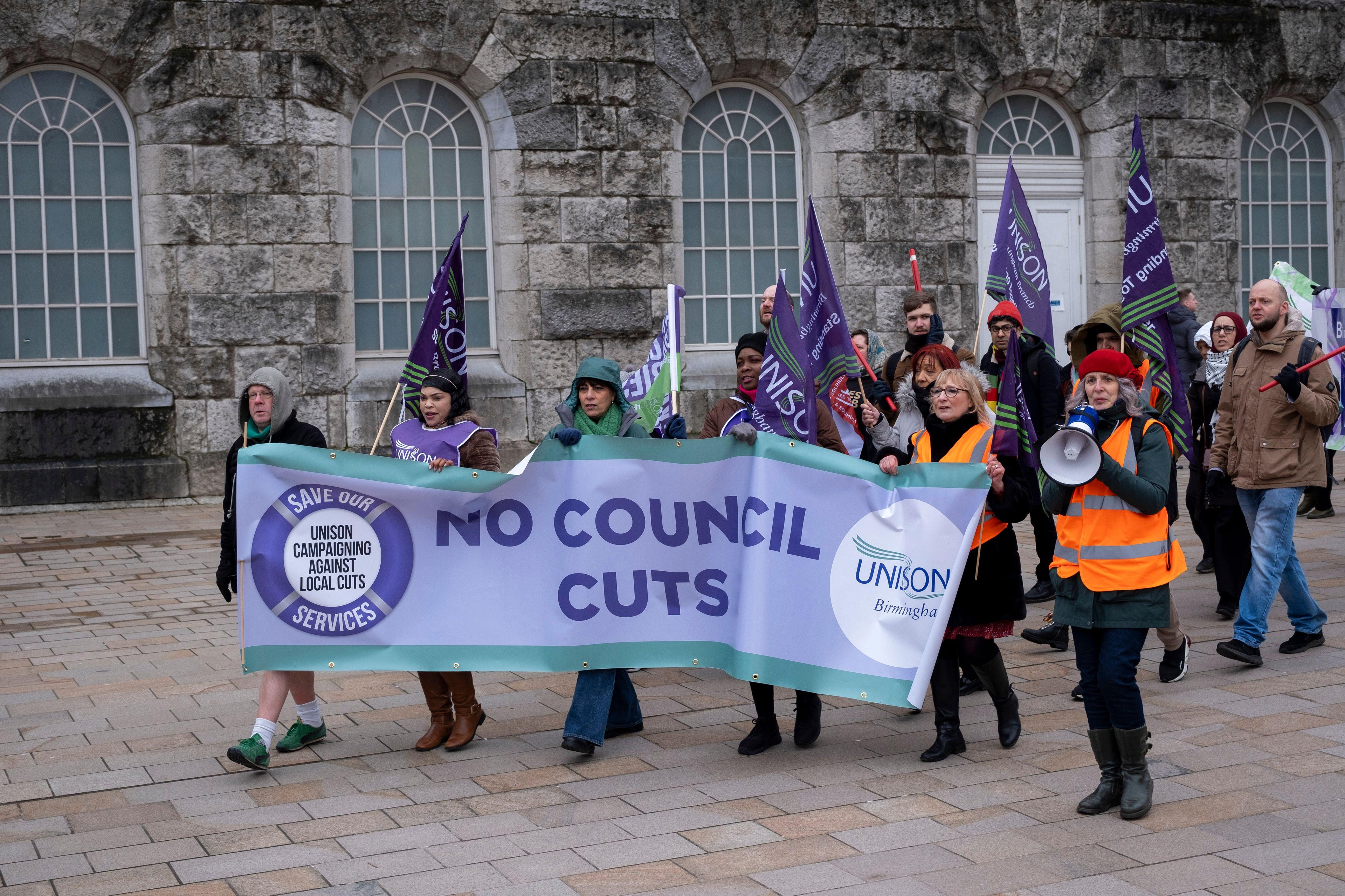 Recent pay protest in Birmingham, with protestors carrying a banner calling for no council cuts, whilst holding flags
