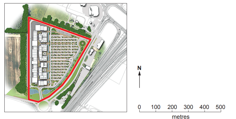Rectangular site plan featuring buildings and green spaces, outlined in red. Adjacent roads and rail tracks shown, with a north arrow and scale bar.