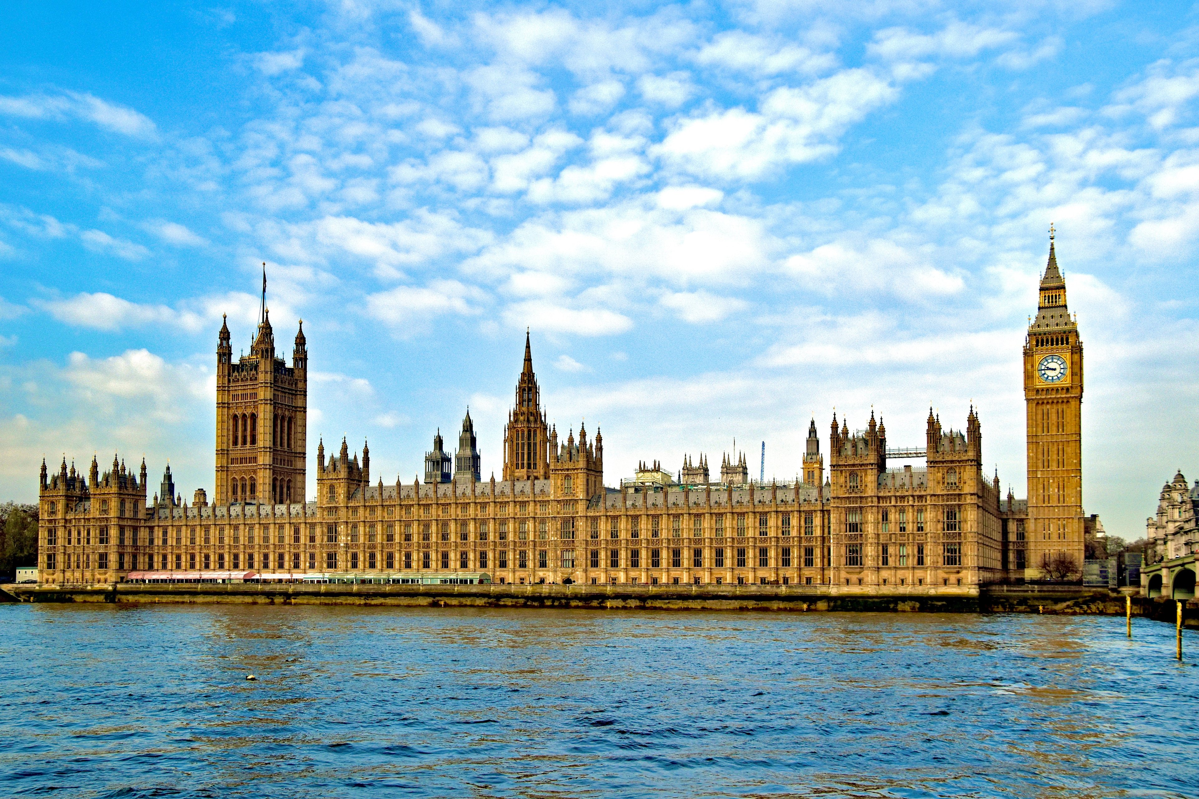 The Houses of Parliament building in London, alongside the River Thames, with Big Ben and Members' Terrace visible