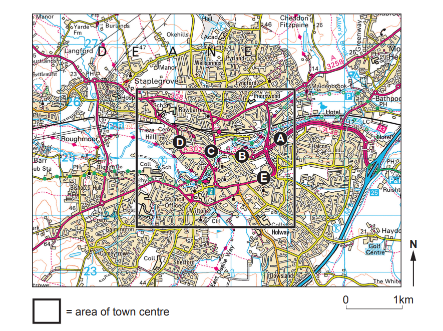 Map showing a town centre with roads marked in magenta, labelled A to E. Includes geographic features, grid lines, and a scale bar at the bottom right.