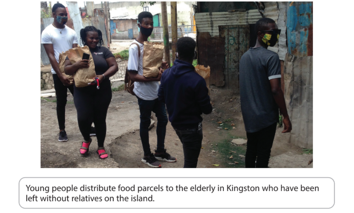 A group of young people, wearing masks, distribute food parcels in a rundown urban area, supporting the elderly in Kingston.