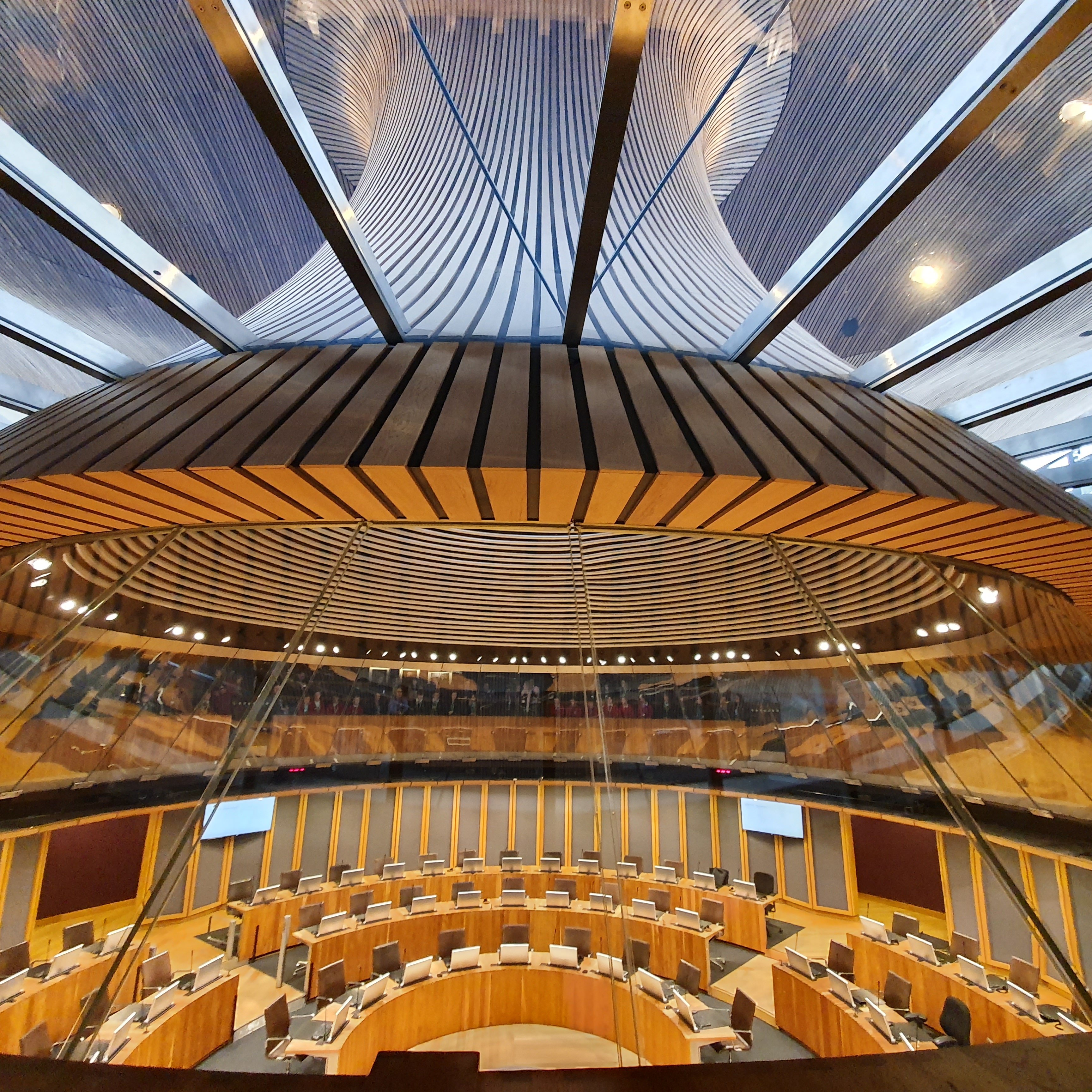 The Senedd debating chamber, with circular seating arrangement and futuristic glass ceiling