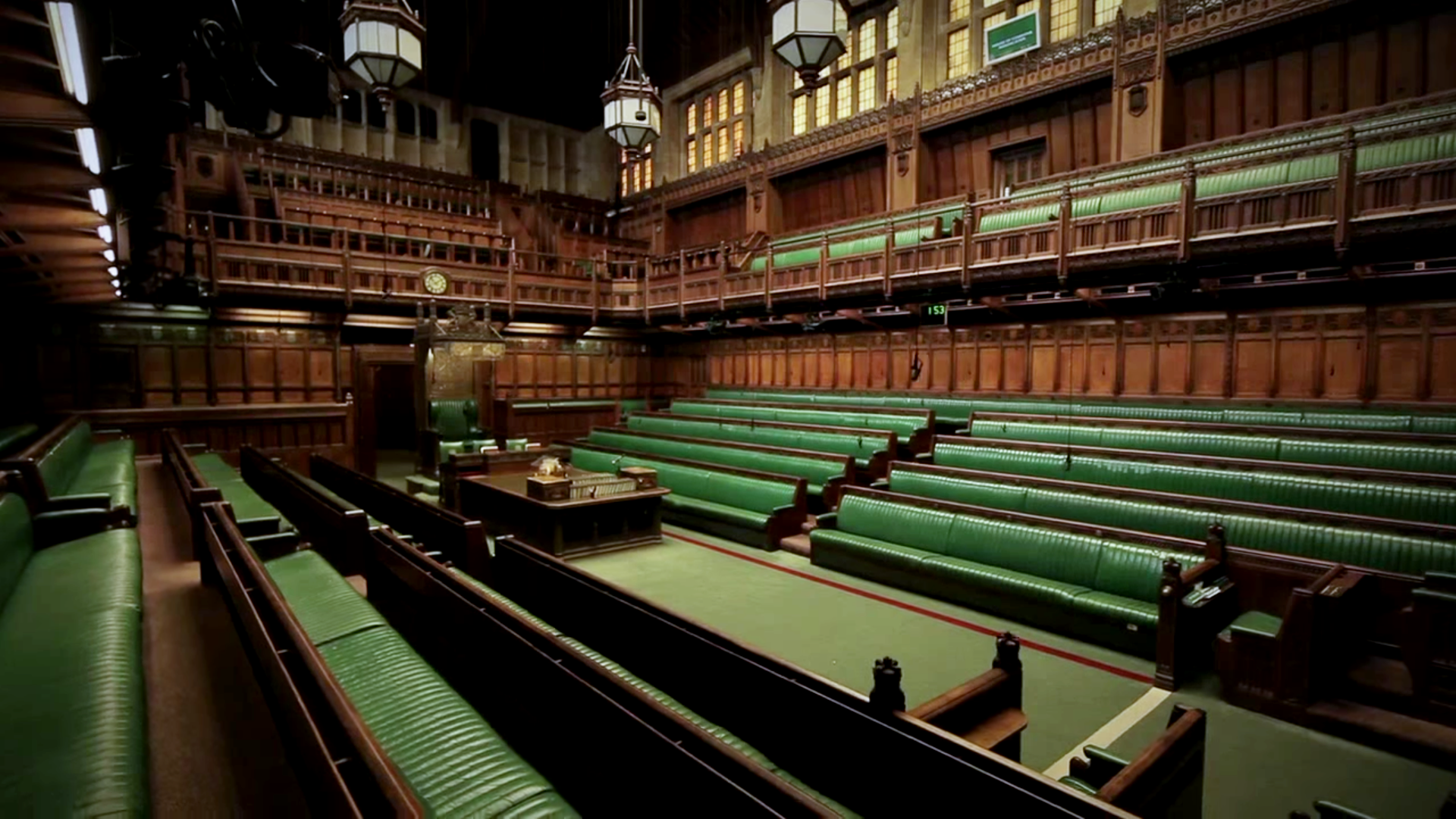 The floor of the House of Commons with its green benches and ornate woodwork