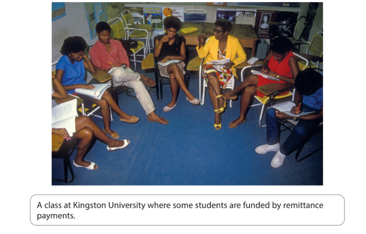 A diverse group of students engaged in discussion in a classroom at Kingston University, sitting in a circle with notebooks on their laps.