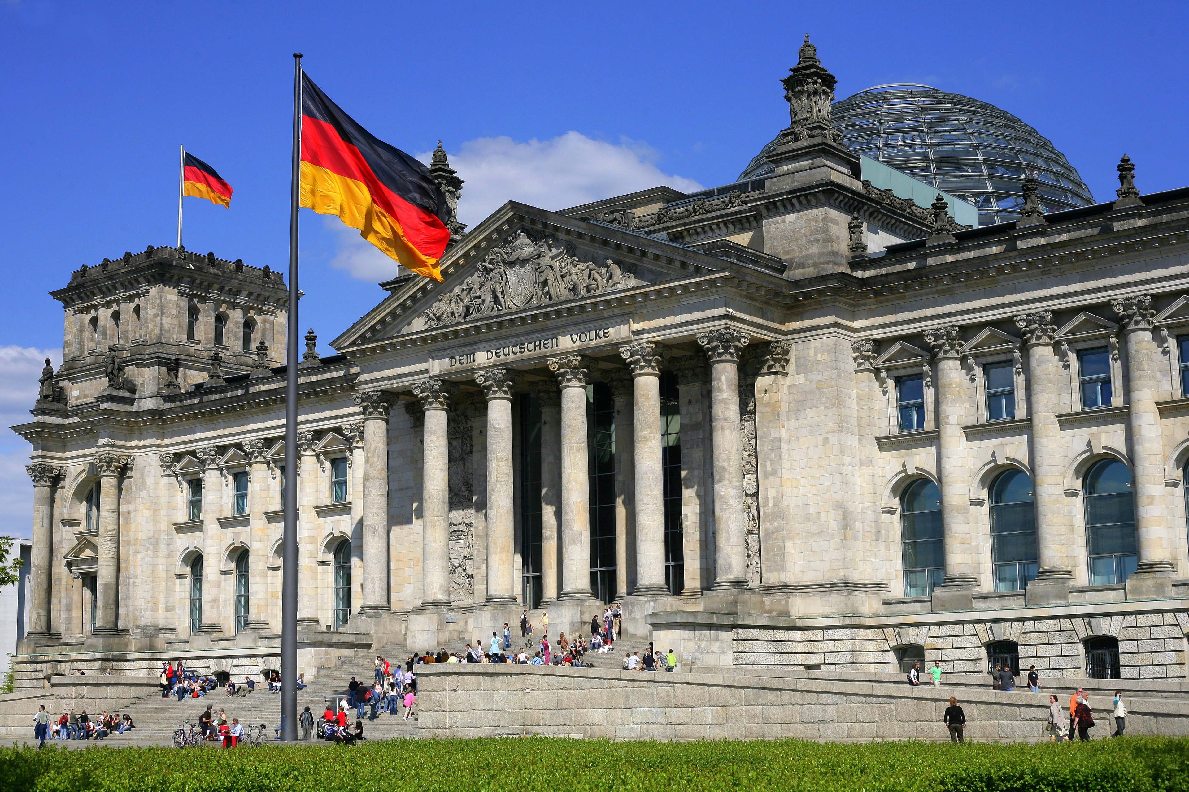 The Reichstag, home of the Bundestag (German Parliament) in Berlin, with the German flag flying in front and on top of the building