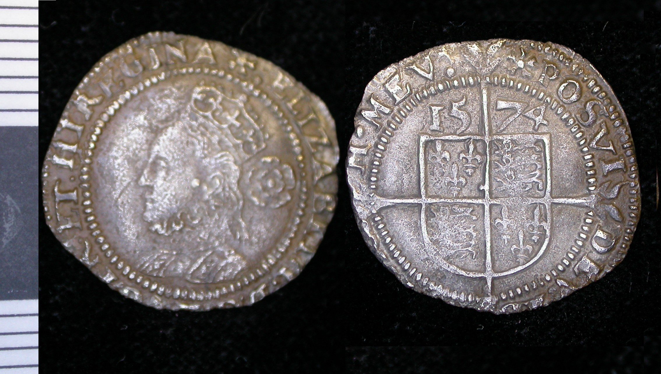 Two silver coins; the left shows a profile of a crowned figure, the right displays a coat of arms with the date 1574, set against a dark background.