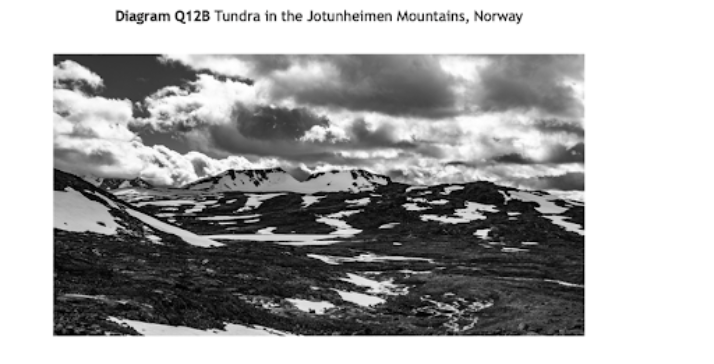 Black and white image of snowy tundra landscape in the Jotunheimen Mountains, Norway, with dramatic clouds in the sky.