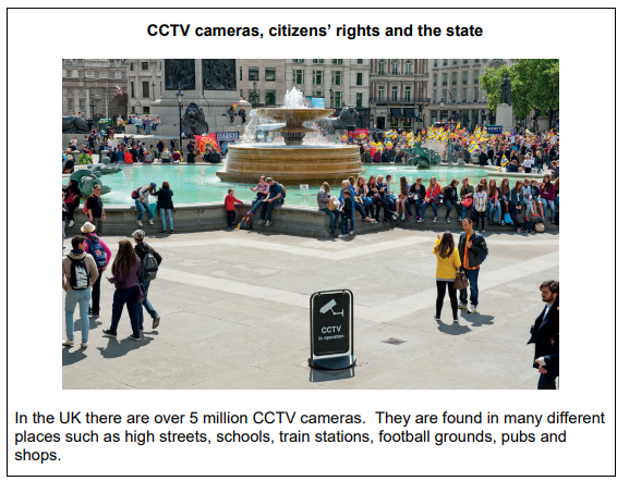 A busy city square with a large fountain and many people sitting and walking. A CCTV sign is prominent, highlighting surveillance presence.