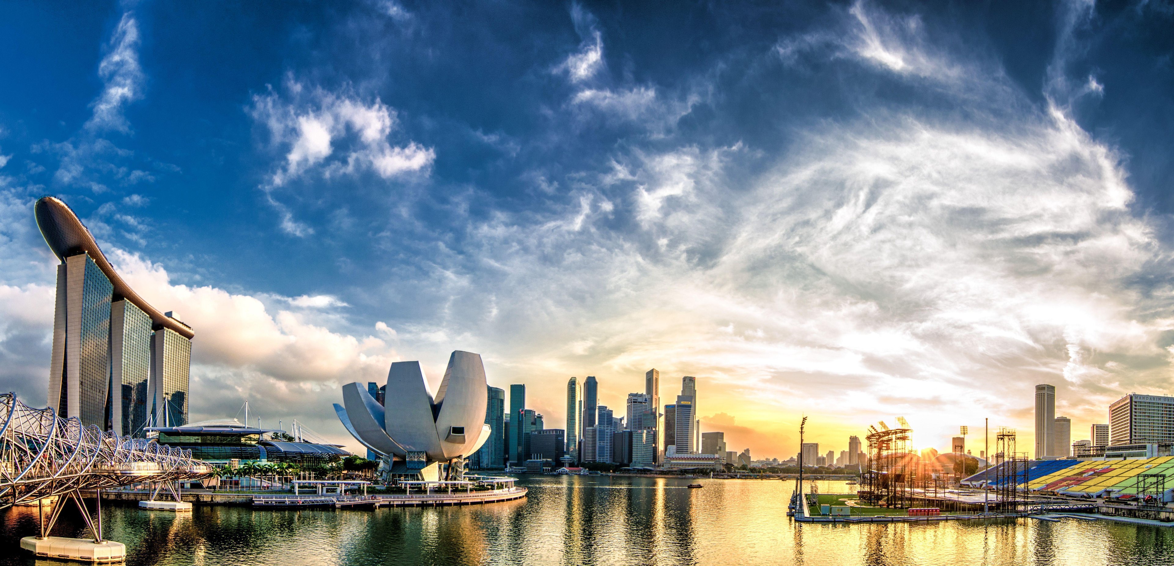 The Singapore skyline with large avant-garde structures, a strong blue sky with high clouds and a waterfront