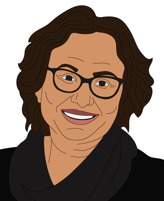 Smiling woman with curly brown hair wearing glasses, a dark jumper, and a necklace against a plain white background.