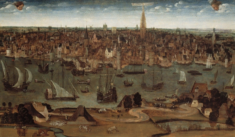 Aerial view of a busy mediaeval port city with numerous ships in harbour, surrounded by buildings and green landscape under a cloudy blue sky.