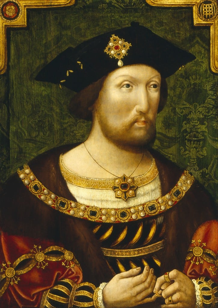 A regal young Henry VIII in ornate Tudor attire and a black hat adorned with jewels, against a green patterned background; his hands are clasped in front.