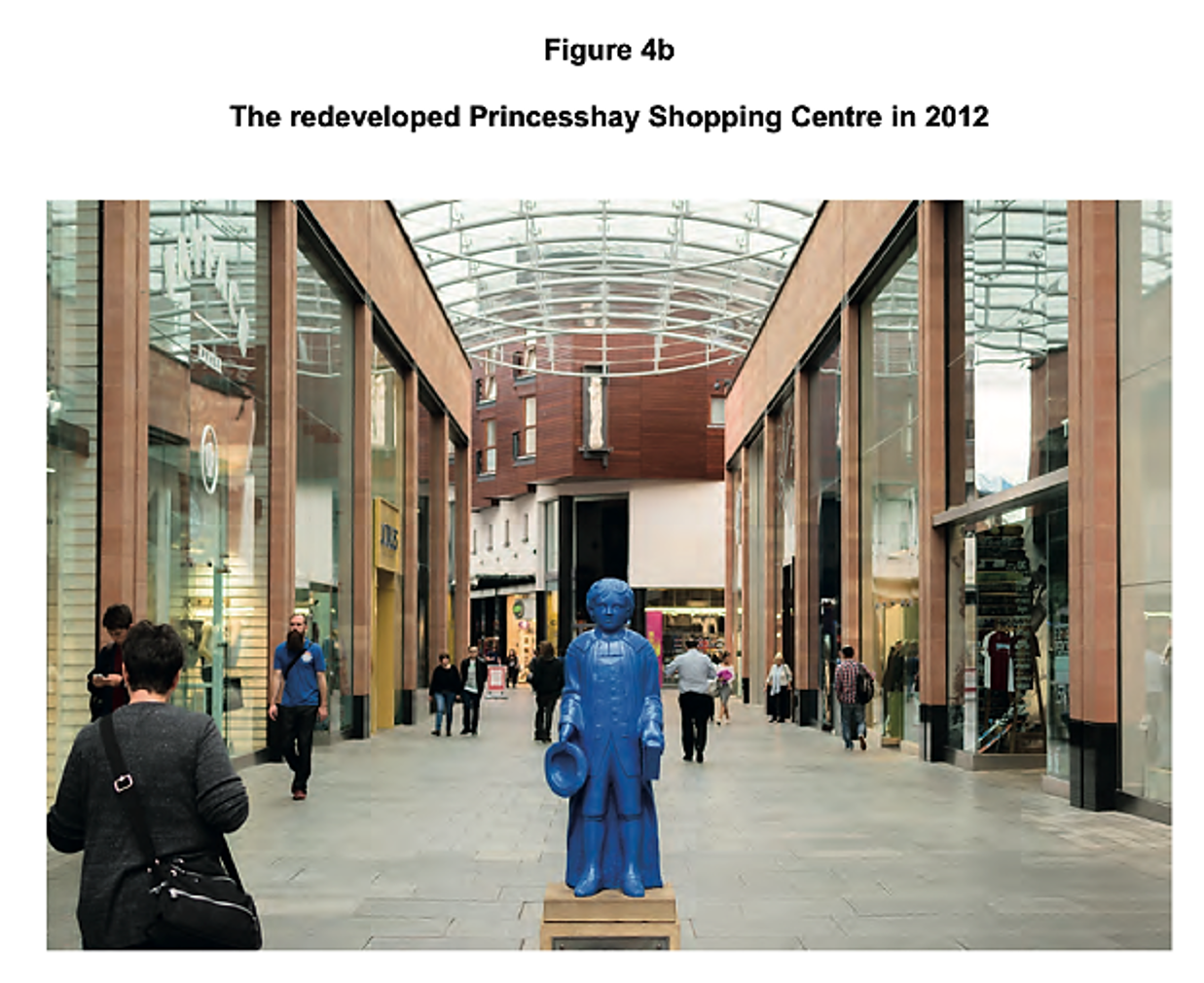 View of the redeveloped Princesshay Shopping Centre, 2012. Features a blue statue of a child holding a hat, with shoppers walking nearby under a glass roof.
