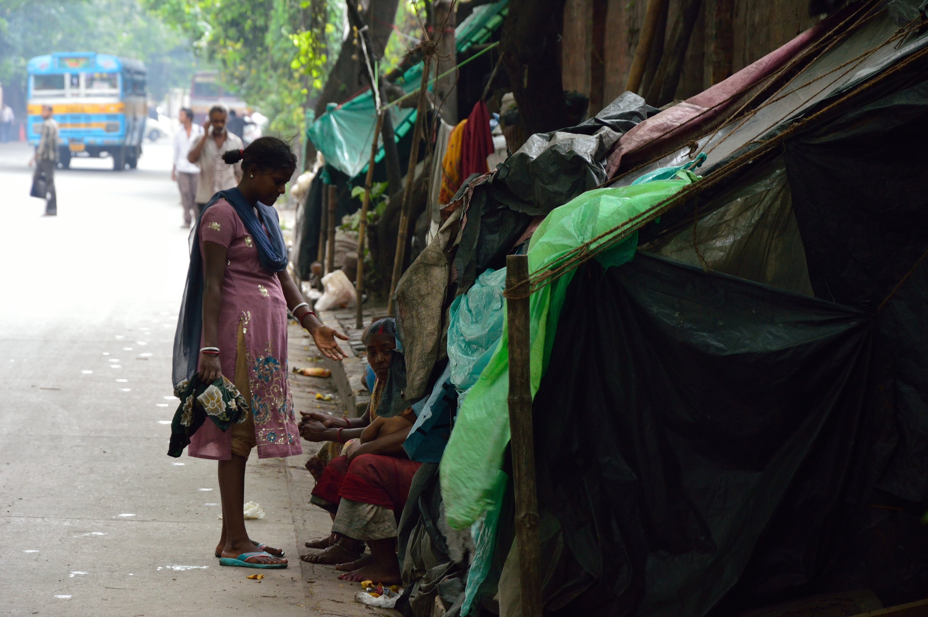 Homeless people living in poorly constructed shelters at the side of a Delhi street