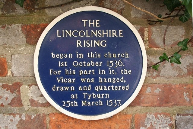 Blue plaque on a brick wall commemorating the Lincolnshire Rising of 1536. It notes the execution of the Vicar at Tyburn on 25 March 1537.