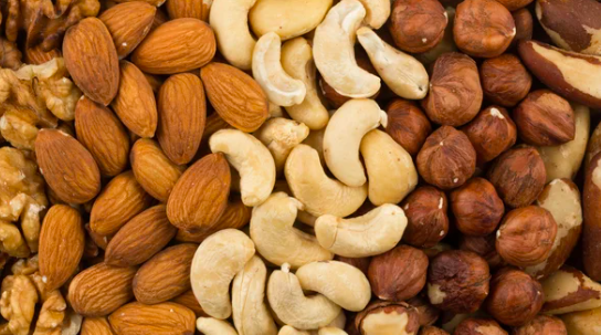 Mixed nuts assortment featuring almonds, cashews, hazelnuts, Brazil nuts, and walnuts in a close-up view, showcasing their varied textures and colours.