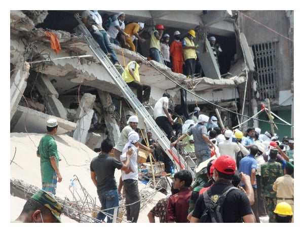 Crowd of rescue workers and volunteers amid debris of a collapsed building, using ladders and ropes to assist trapped individuals.