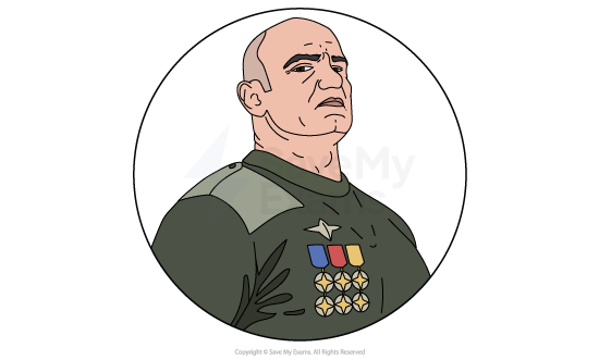 Image of Creon from Antigone: he is a stern, bald military officer in a dark green uniform, shown from the chest up, wearing multiple colourful medals and badges.