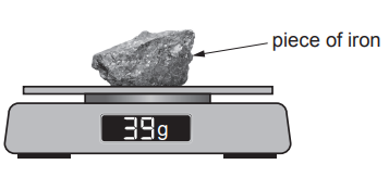 Digital scale weighing a rough piece of iron, with the display reading 39 g and an arrow labelling the metal sample