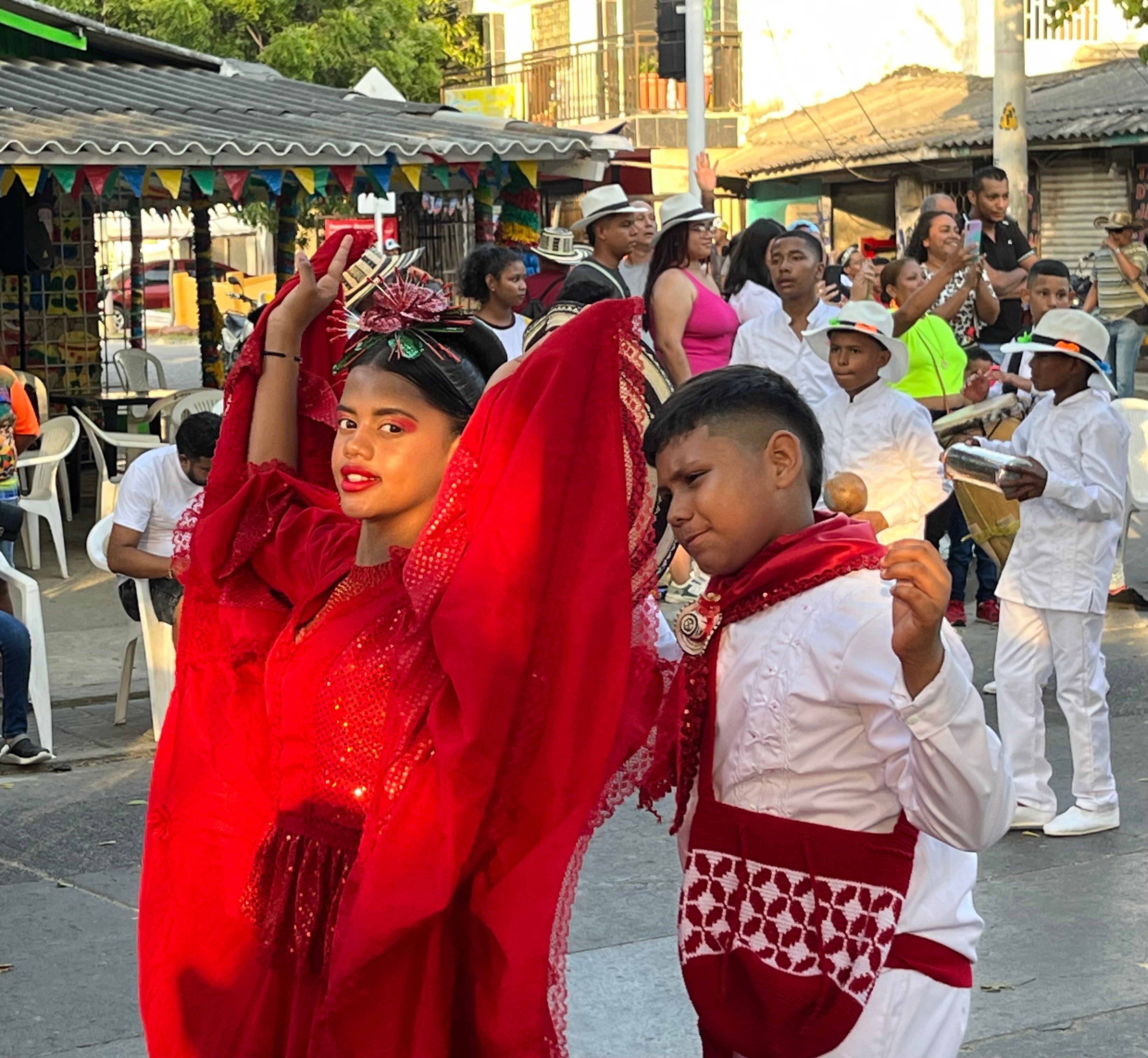 Children dancing at a street parade in traditional Colombian costume