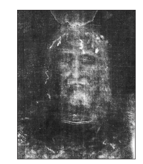 Faded monochrome image of a bearded man’s solemn face, front-facing, emerging ghostlike from a dark, textured background