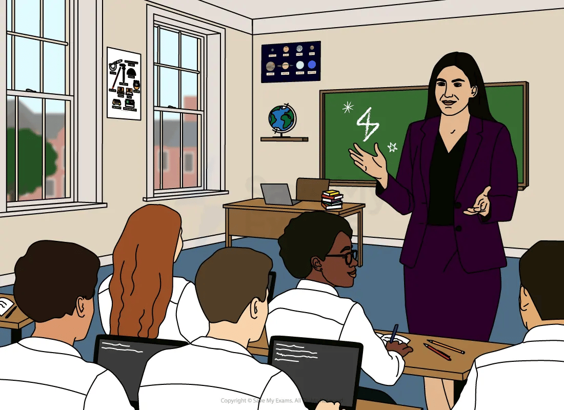 Teacher in a purple suit explains at the front of a science classroom while students in white shirts take notes on laptops and paper.