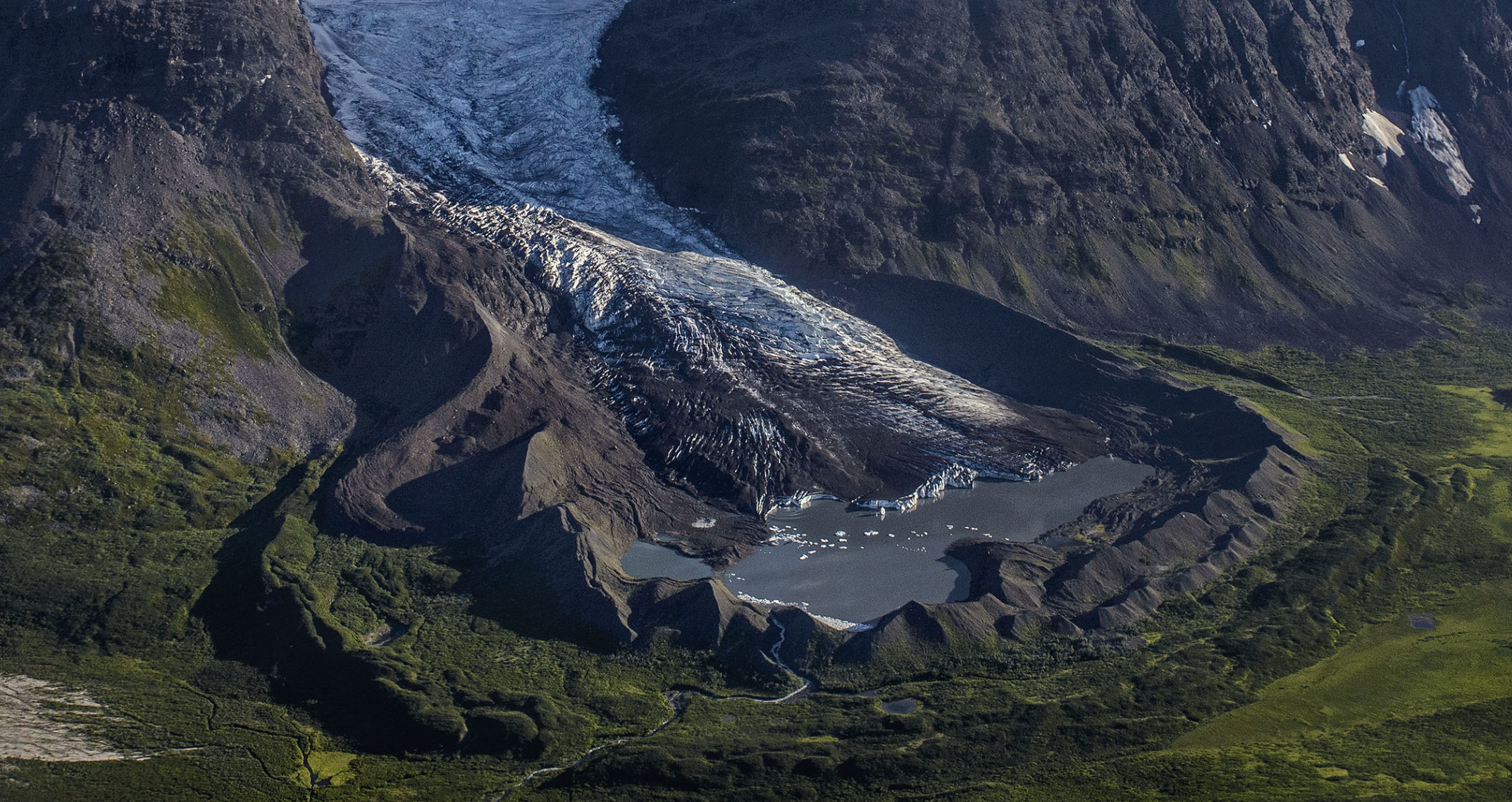 Photograph showing a glacier with lake and surrounding raised areas