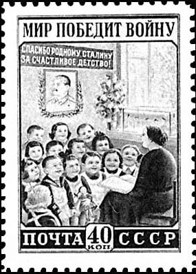 Soviet postage stamp showing teacher reading to smiling children beneath a framed leader’s portrait and Russian pro-peace propaganda slogans