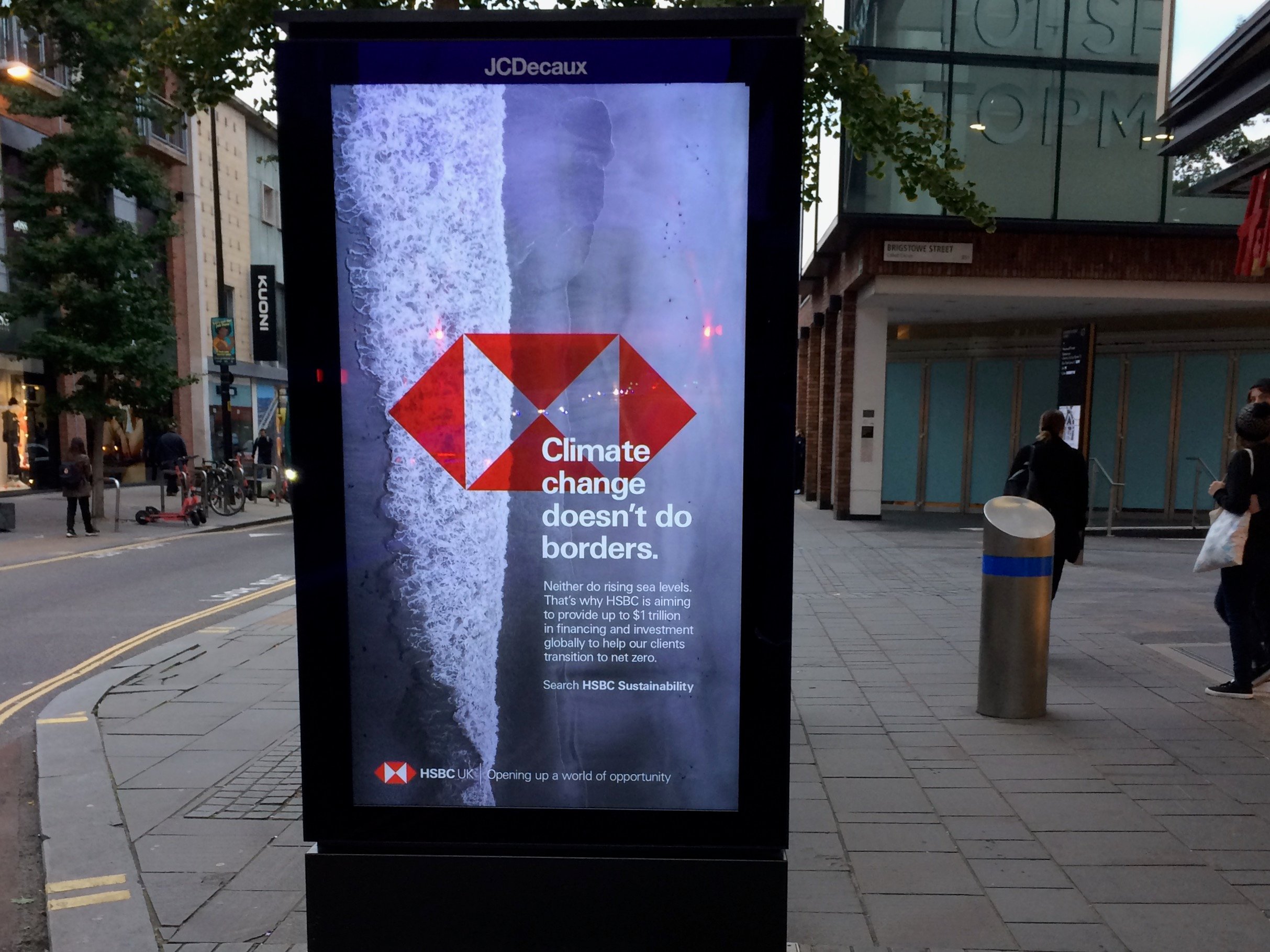 HSBC bus stop advert showing shoreline with waves and text about climate change, rising sea levels and the bank’s global net zero financing commitment