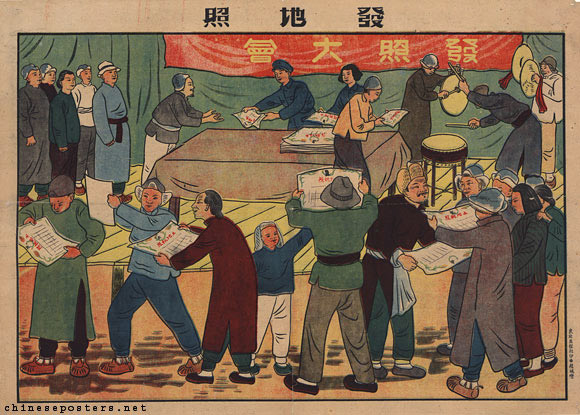 Crowd of Chinese villagers eagerly receiving and reading newspapers at an outdoor distribution table beneath a red propaganda banner and stage.
