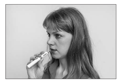 [Figure: Photograph of a person's hand holding an e-cigarette]