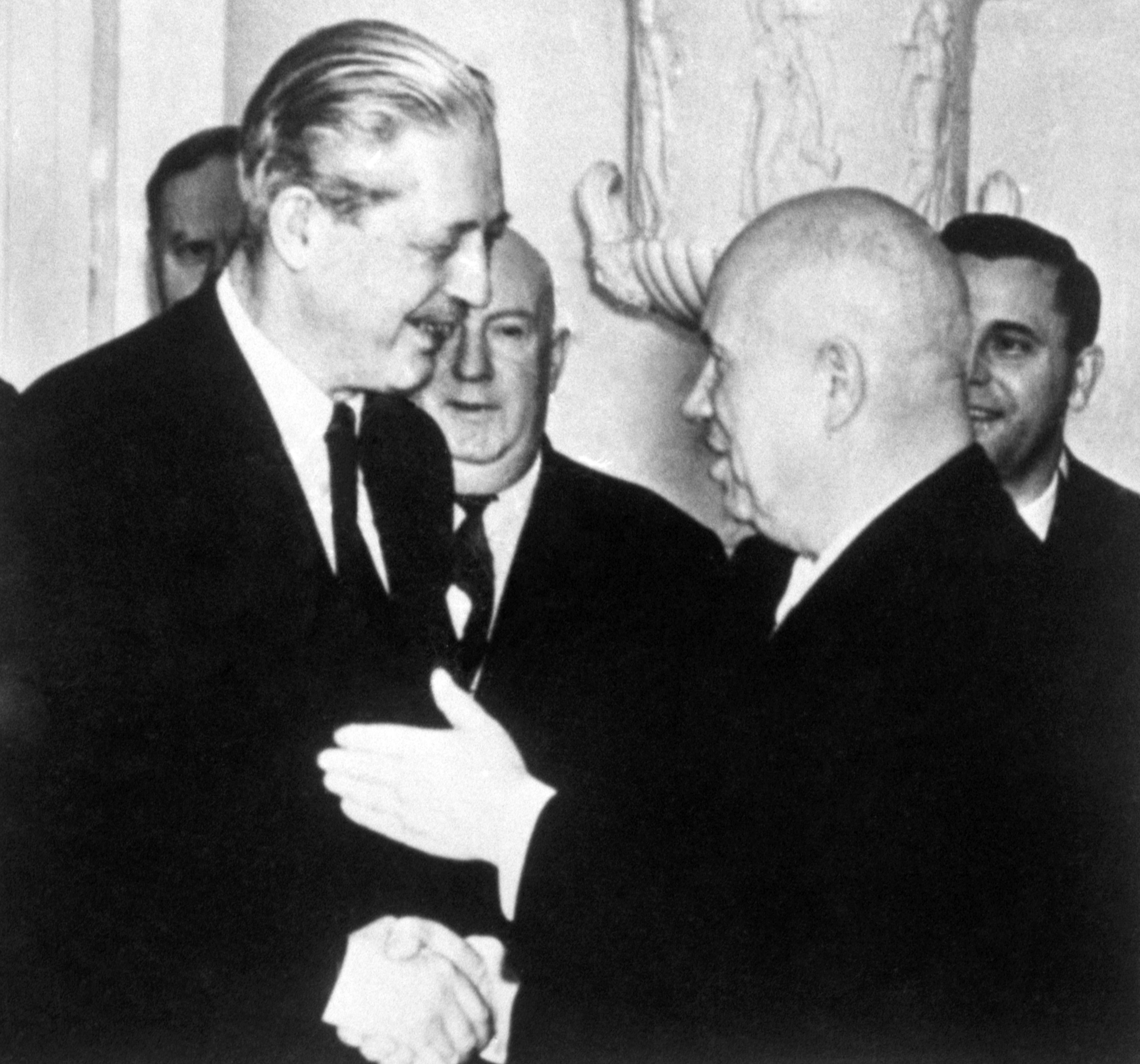 Black-and-white photograph of Macmillan meeting Soviet leaders Nikita Khrushchev, showing the men in suits standing closely together and smiling during Cold War diplomacy.